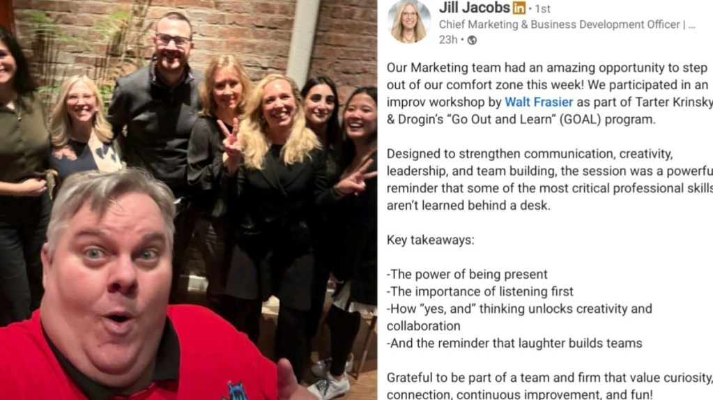 A group photo featuring a diverse marketing team posing happily after an improv workshop, with one person taking a selfie in the foreground. The background shows a brick wall and decorative plants.